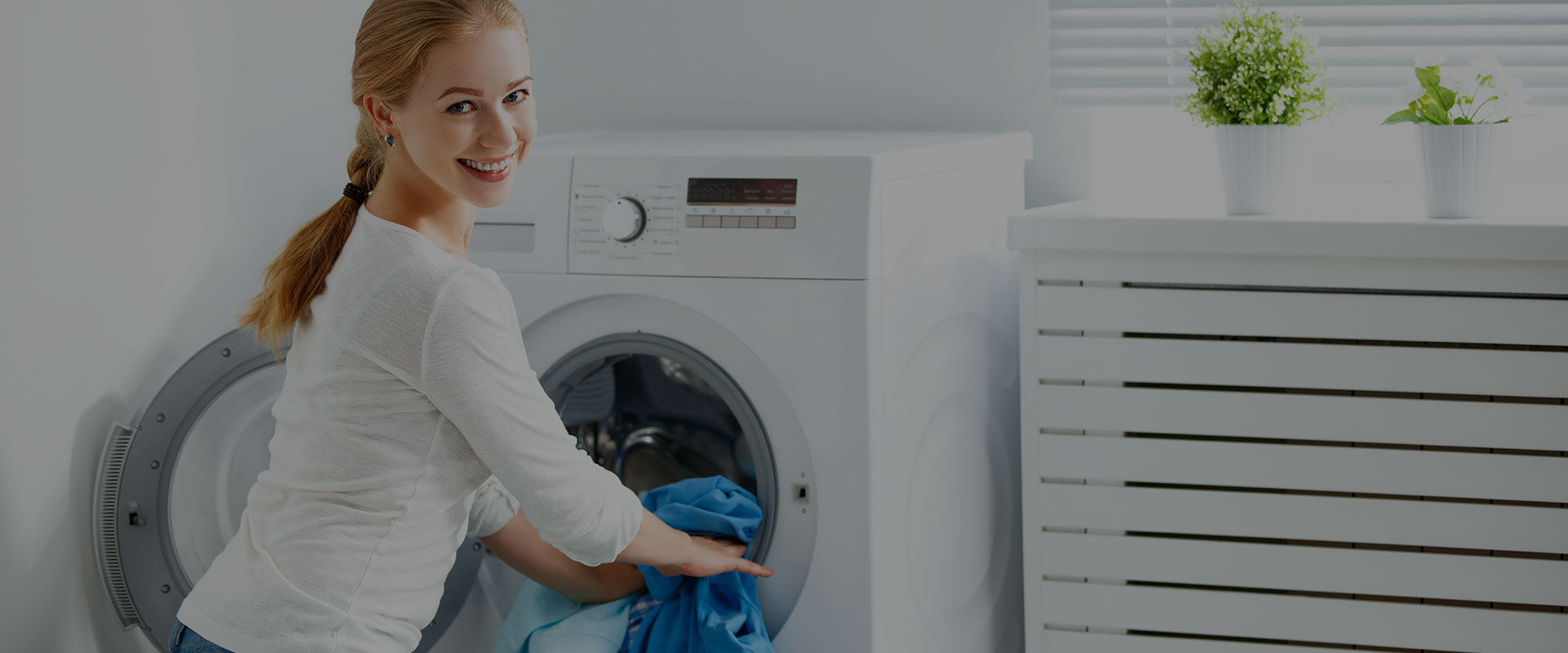 A smiling customer loading a washing machine